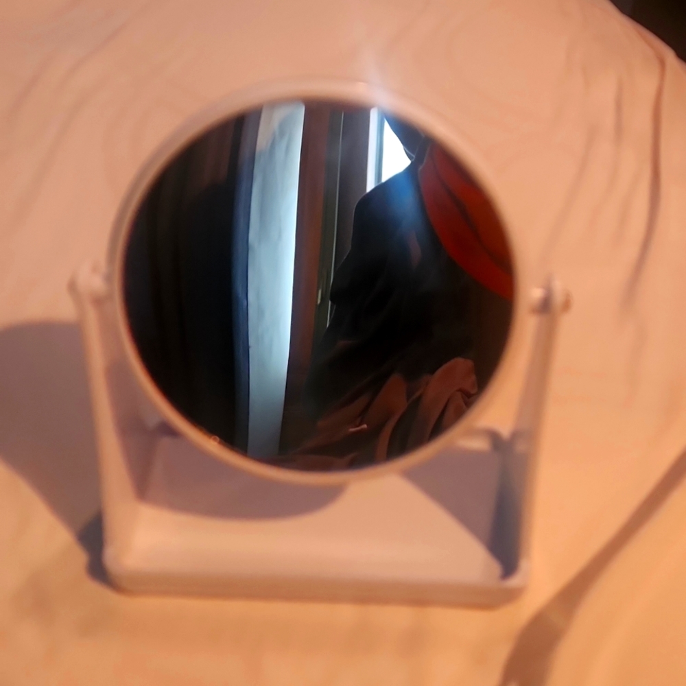 White double-sided vanity mirror with one side magnified.